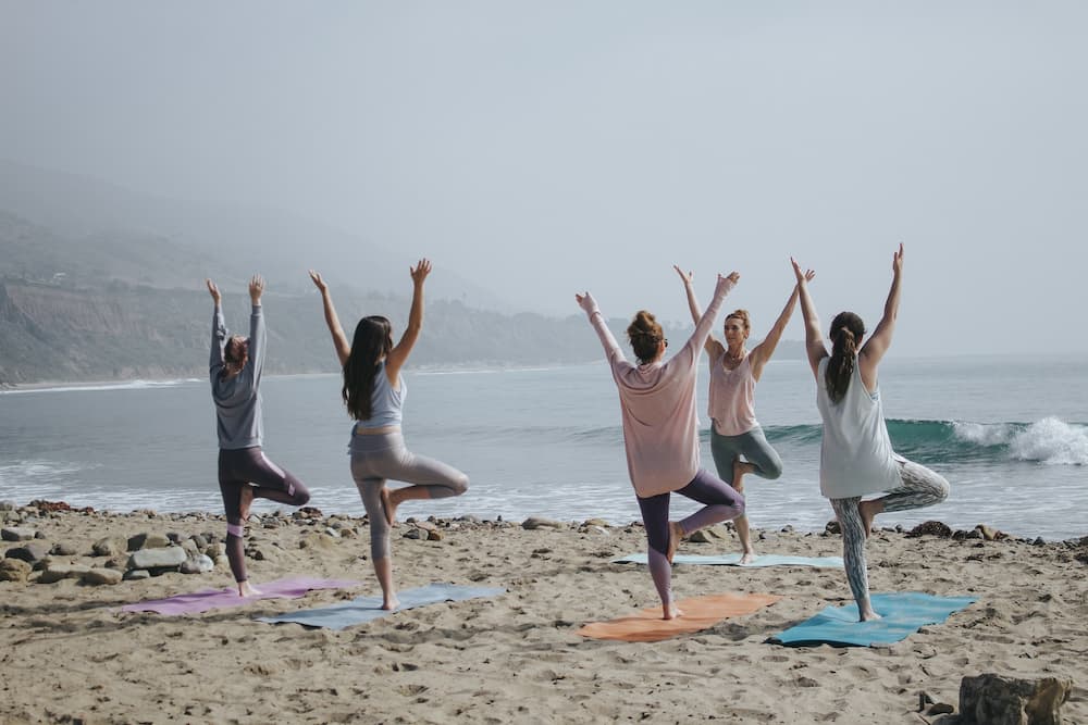 group of women performing outdoor yoga